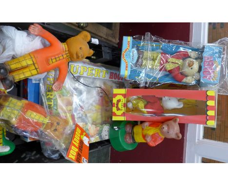 A collection of Rupert Bear games, money boxes, a lamp, Pelham Puppet, Bendy toy, etc.