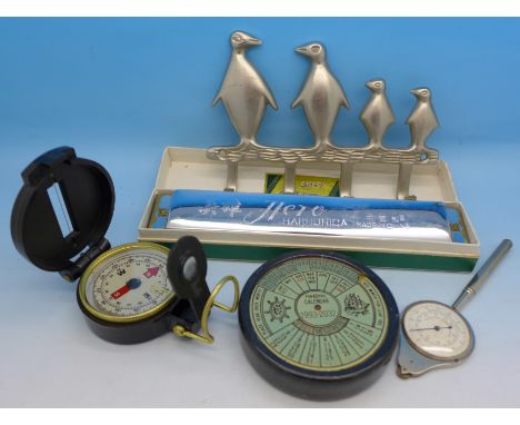 A map gauge, a compass, a 40 years calendar, Hero harmonica and a novelty penguin coat hook