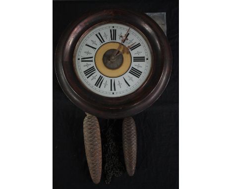A 19th century Black Forest postman's alarm clock with black Roman numerals and fir cone weights. Dia.28cm.(face) 