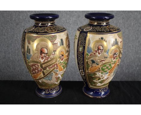 A pair of early 20th century ceramic satsuma hand painted Japanese vases in raised relief decoration. With the maker's mark o