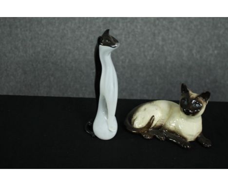 A ceramic and glass cat. The ceramic cat made by Beswick Pottery. The black-and-white glass cat with a lightly chipped ear .H