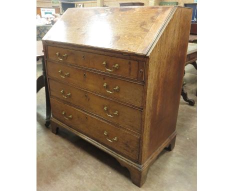 A George III oak Bureau with fitted interior raised on bracket supports