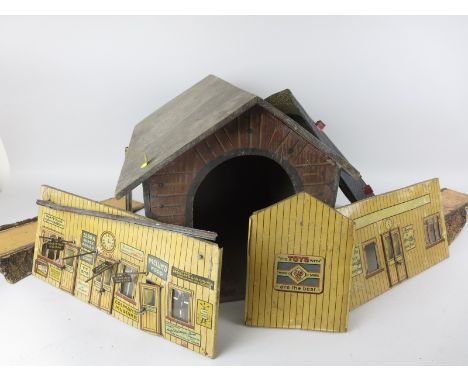 A box of 0 gauge tinplate Station and Signal Boxes, a wooden engine shed, a pair of tinplate tunnel entrances, etc