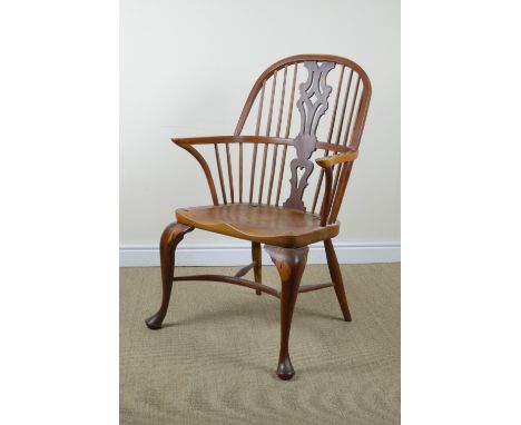 A reproduction yew and elm Windsor Elbow Chair with pierced splat and stick back, solid seat on cabriole front legs united by