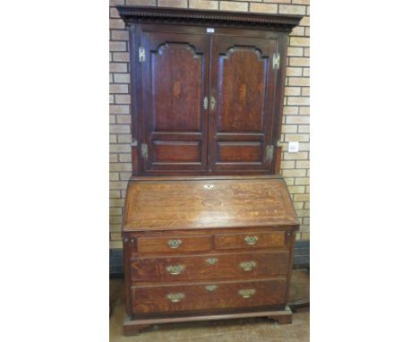 An antique oak Bureau Bookcase having a pair of inlaid panelled doors flanked by fluted quarter round pilasters, the base wit