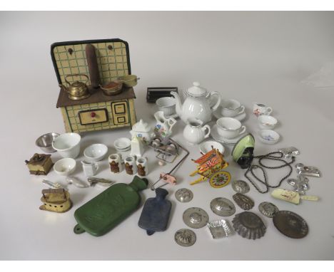 A doll's tinplate Kitchen Range with pans marked MFZ, metal moulds, coffee grinder, part silver edged china tea set, mixing b