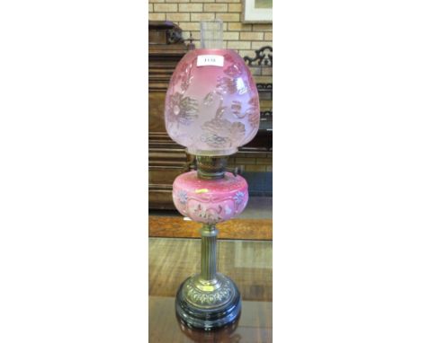 A Victorian Oil Lamp with fluted brass column, painted pink opaque reservoir and pink shade