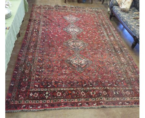 An Oriental Carpet with central design of four diamond with multi- pattern all over designs on a chiefly red ground, multi bo