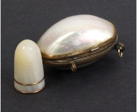 A mother of pearl Palais Royal style thimble with double gilt frieze, contained in a mother of pearl egg with gilt metal fram