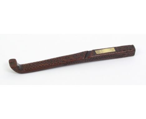 An early 19th Century chip carved knitting stick set with a rectangular brass plaque, leaf carving to sides, 17.5cm
