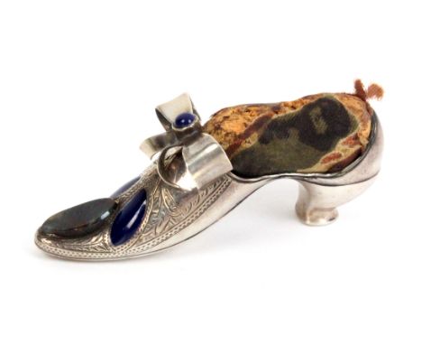 A silver and embellished pin cushion in the form of a lady's shoe the point with oval agate and two blue enamel panels within