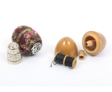 Two thimble cases comprising a beadwork covered bone example with thimble, 4cm, and a vegetable ivory example with reel/needl