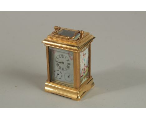 A BRASSS THREE PIECE MINIATURE CARRIAGE CLOCK with painted panels and carrying handle. 8cm high.