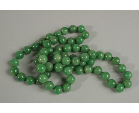 A GOOD STRING OF SIXTY SIX GREEN JADE BEADS. 80cm long.