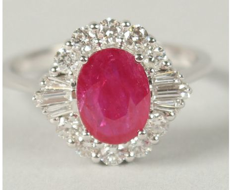AN 18CT WHITE GOLD OVAL RUBY, RBC AND BAGUETTE DIAMOND CLUSTER RING. Ruby 1.26ct.  Diamonds 0.5ct.