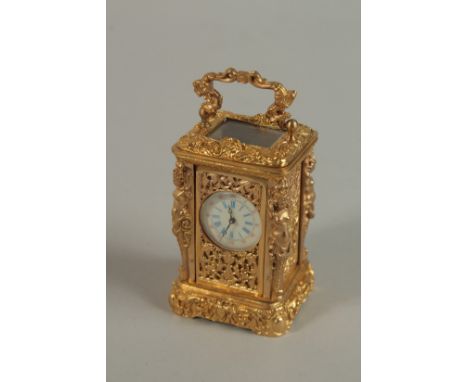 A MINIATURE BRASS ORNATE CARRIAGE CLOCK with finial mounts and carrying handles. 7cm high.