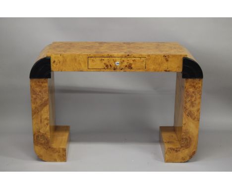 AN ART DECO DESIGN BLOND WOOD CONSOLE OR DRESSING TABLE with a single frieze drawer and curving end supports with ebonised de