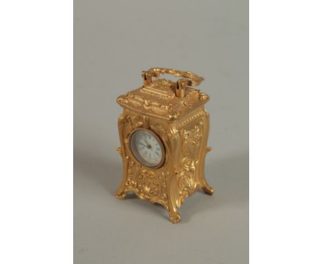 A MINIATURE BRASS ORNATE CARRIAGE CLOCK with acanthus scrolls and carrying handles. 7cm high