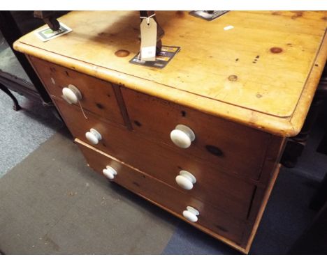 A small Victorian chest of two short over two long drawers having ceramic handles resting on turned supports