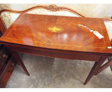 A flame figured chequer strung and inlaid mahogany card table, the folding top with green baize insert raised on square taper