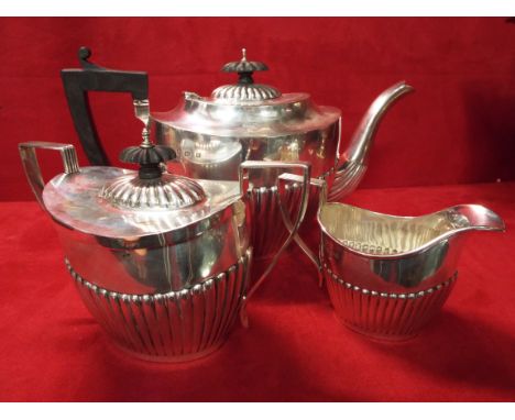 An early 20thC silver three piece tea set of gadrooned form comprising tea pot, sugar bowl and milk jug dated Birmingham 1911