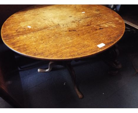 A Georgian oak snap-top table resting on tripod stand