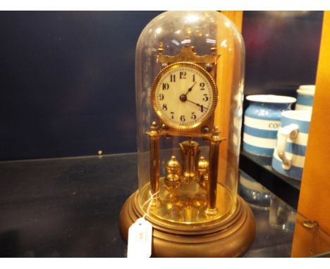 An early 20thC German gilt brass torsion clock with enamel dial and Arabic numerals, no.146380 complete with glass dome