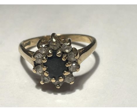 A 9 CARAT GOLD RING WITH A CENTRE SAPPHIRE SURROUNDED BY CLEAR STONES SIZE I 