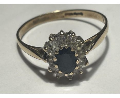 A 9 CARAT GOLD RING WITH A CENTRE SAPPHIRE SURROUNDED BY CUBIC ZIRCONIA STONES SIZE T 