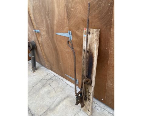 A VINTAGE CAST IRON WATER PUMP MECHANISM ON A WOODEN BOARD 