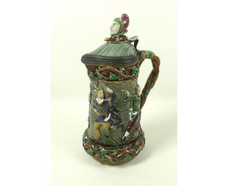 A Minton Majolica lidded jug, the shell moulded lid with jester's head finial, Britannia metal mounts, over an entwined branc