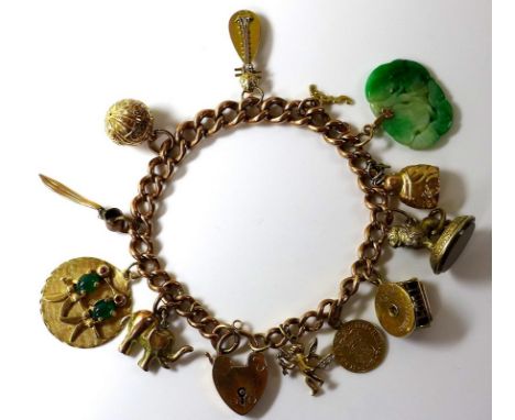 A 9ct gold charm bracelet, with twelve charms, including five 14ct charms and a carved jade disc, with heart shaped padlock c