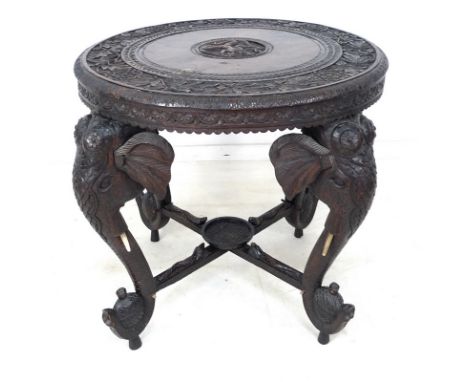 An Anglo-Indian carved table, the circular top profusely engraved with floral scroll engravings, the centre depicting a deity