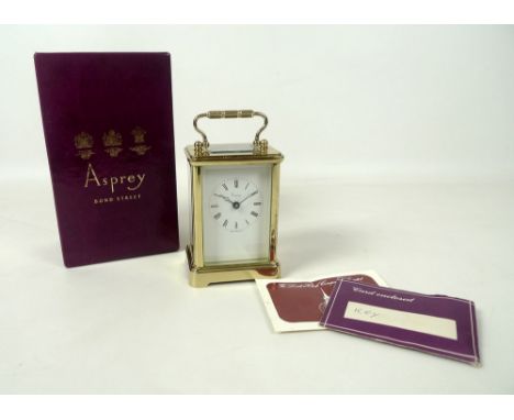 A 20th century brass carriage clock by Asprey, with French movement and key, the white enamel dial with Roman numerals and ma
