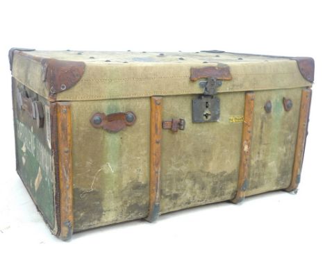 An Edwardian green canvas trunk, leather cornered and handles, various shipping labels still attached, named to side 'Katheri