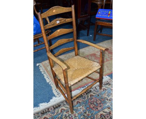 A GEORGIAN OAK RUSH SEATED LADDER BACK ARMCHAIR