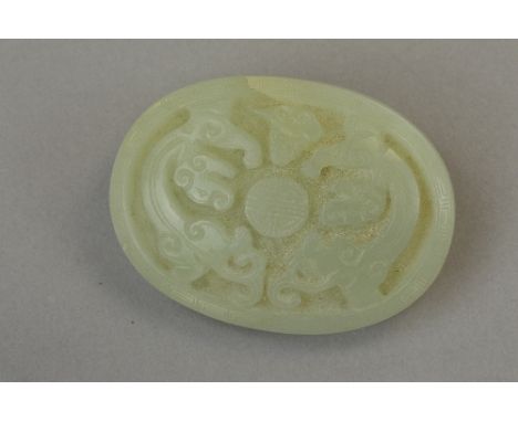 A PALE JADE OVAL PAPERWEIGHT CARVED WITH MYTHICAL CREATURE