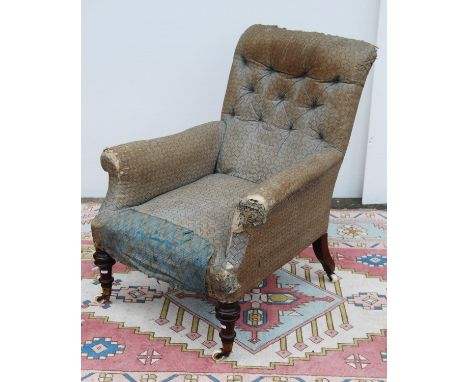 Victorian button-back easy chair with cushioned arms and seat, baluster turned legs terminating in brass caps and ceramic cas