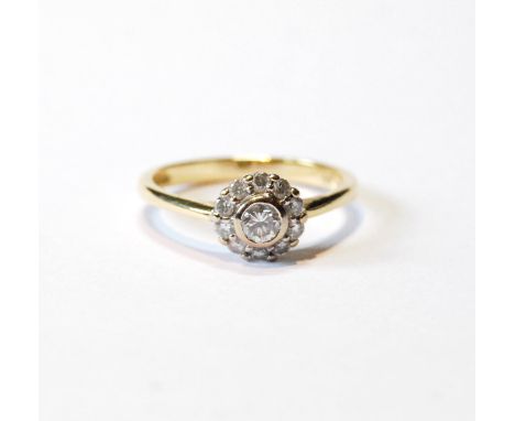 Diamond cluster ring with collet-set brilliant, approximately .5ct, and others smaller, in 18ct gold, size R.CONDITION REPORT