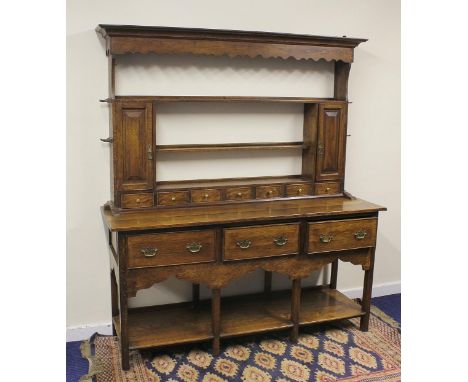 Attractive 18th century and later oak dresser, the plate rack flanked by two panelled door cupboards over seven spice drawers