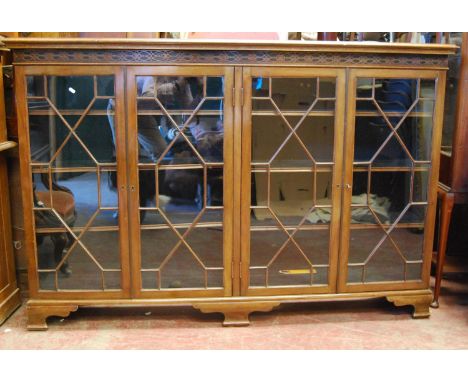 George III style mahogany bookcase, the moulded rectangular top over closed fretwork frieze, four astragal glazed doors enclo