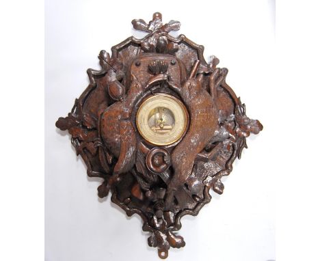 Victorian carved Black Forest wall panel barometer adorned with oak leaves, game and shooting items, with a central aneroid b