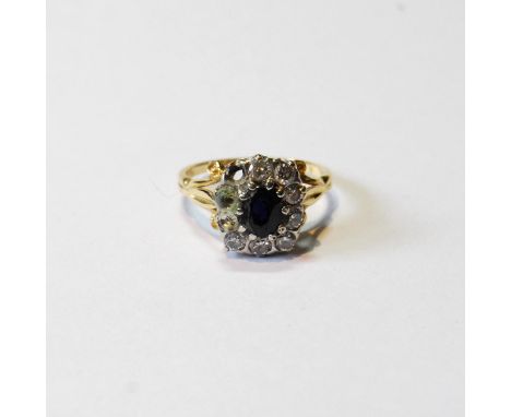 Diamond and sapphire oval cluster ring in gold, probably 18ct (one diamond missing, two replaced with paste), size O. 