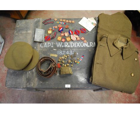 Military ephemera relating to Captain WR Dixon, 182485 Royal Artillery including cap, trench coat, badges, tags, pips, travel