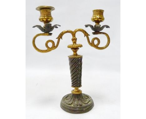 Neoclassical gilt metal candlestick with opposing scrolling serpentine branches terminating in leaf drip trays, on barley twi