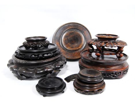 Nine oriental carved wood stands.CONDITION REPORT: All show signs of wear and tear.  Sizes: 23cm, 21cm, 19cm, 20cm, 15cm, 9.5