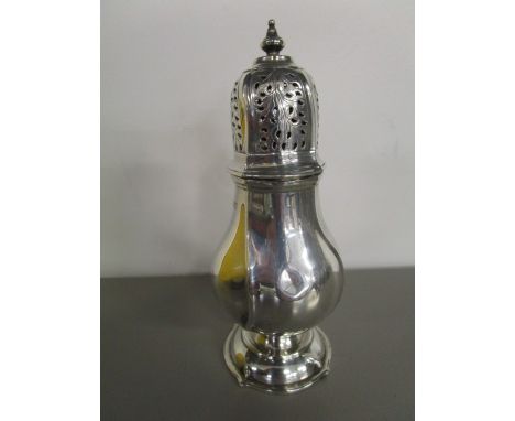 A silver baluster shaped sugar shaker with moulded, fluted decoration on a domed foot, Rd No 552901, London hallmarks for 191