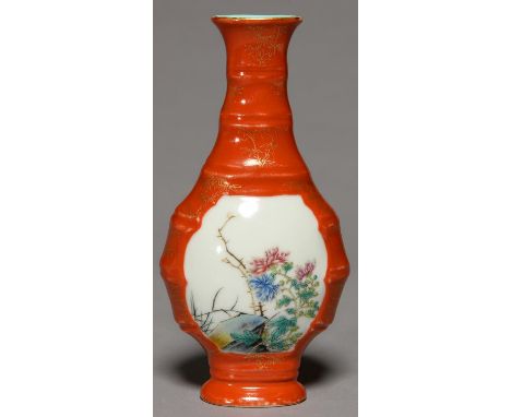 A CHINESE CORAL GROUND FAMILLE ROSE VASE OF BALUSTER SHAPE AND BAMBOO-MOULDED, PAINTED WITH A PANEL OF NATURALISTIC PLANTS, T