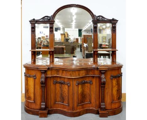 A VICTORIAN MAHOGANY SERPENTINE MIRROR BACKED SIDEBOARD, THE LOWER PART ENCLOSED BY PANELLED DOORS, THE UPPER PART WITH TRIPL