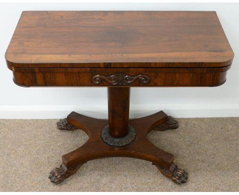 AN EARLY VICTORIAN ROSEWOOD CARD TABLE, THE FOLD-OVER TOP ON TAPERED PILLAR, CALYX AND PLATFORM, CARVED PAW FEET, BRASS CASTO
